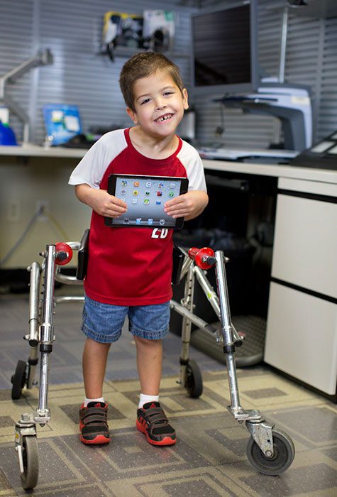 Young boy holding an iPad at an Assistive Tech Demo, Taken by Raminta Zebrauskas - AMAC Team Photographer