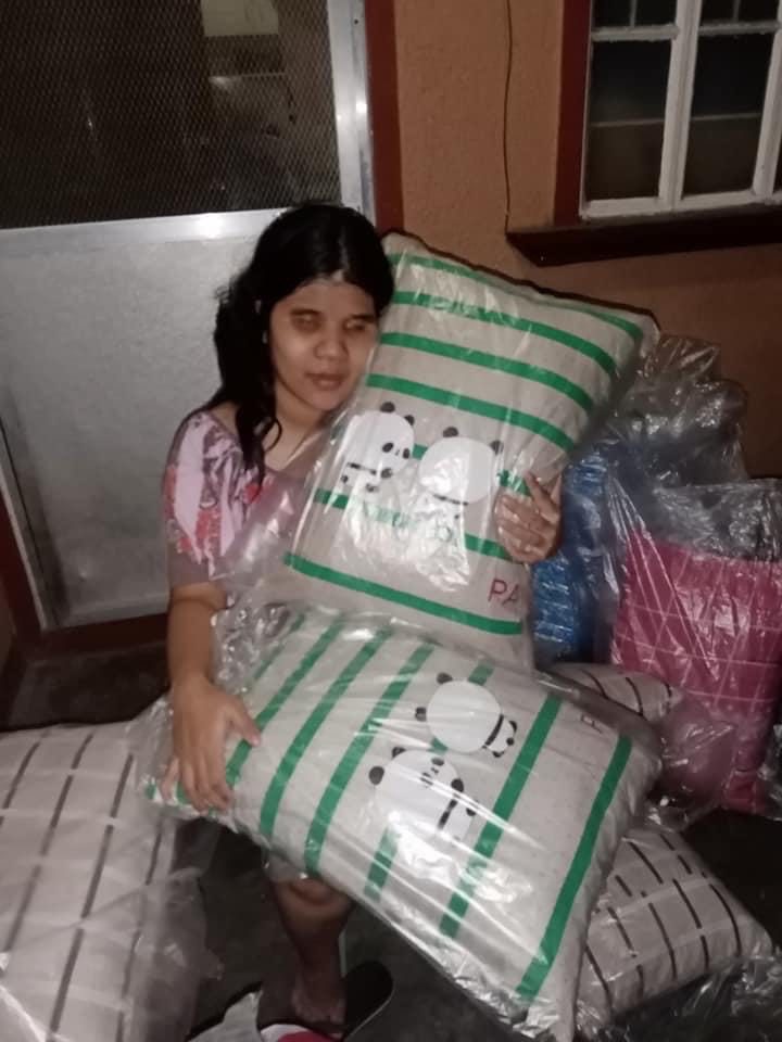 Blind woman with pillows she sells online. 